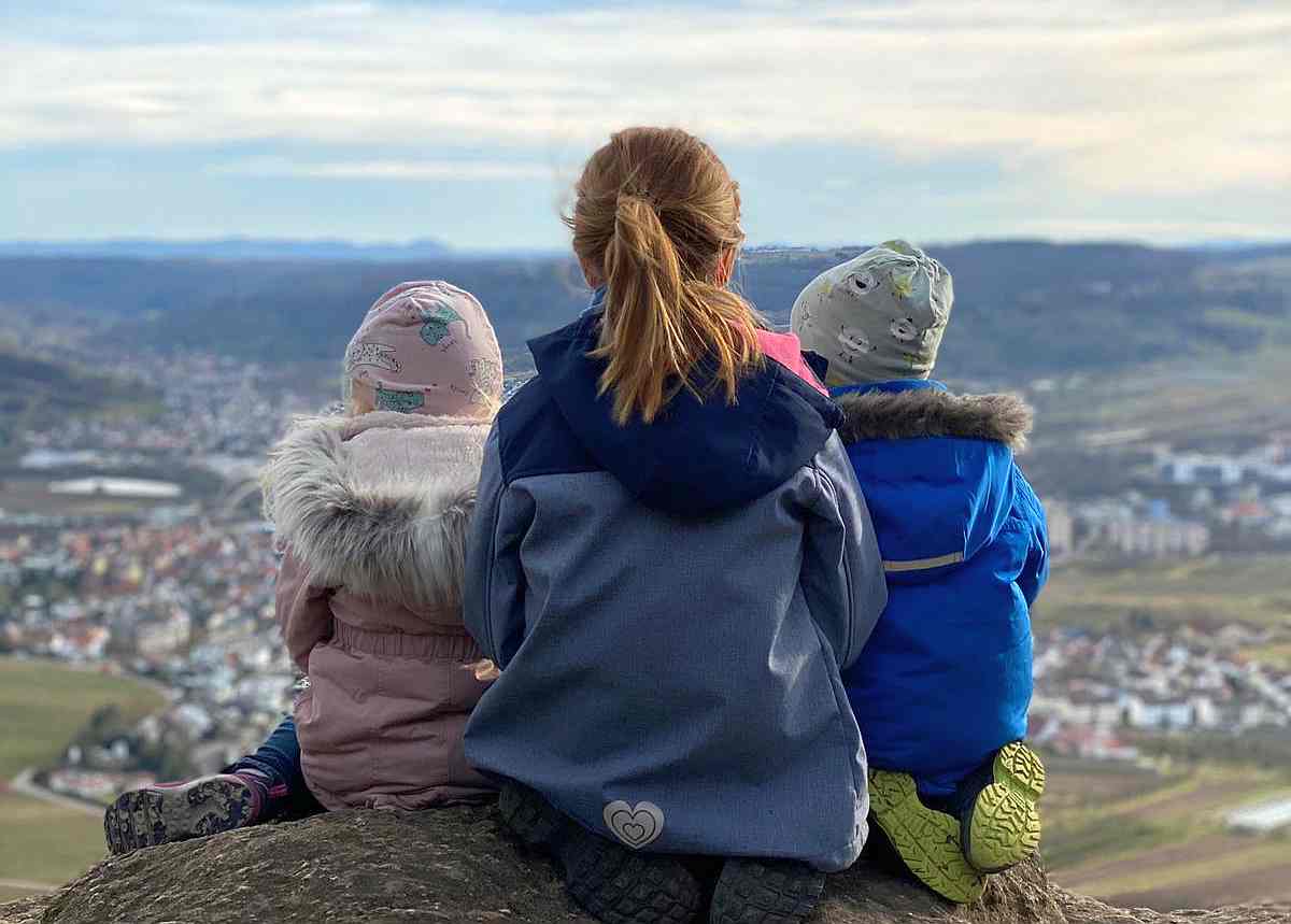 Foto von drei Kindern auf Fels sitzend
